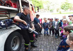 Dzieci oglądają sporzęt w wozie strażackim.